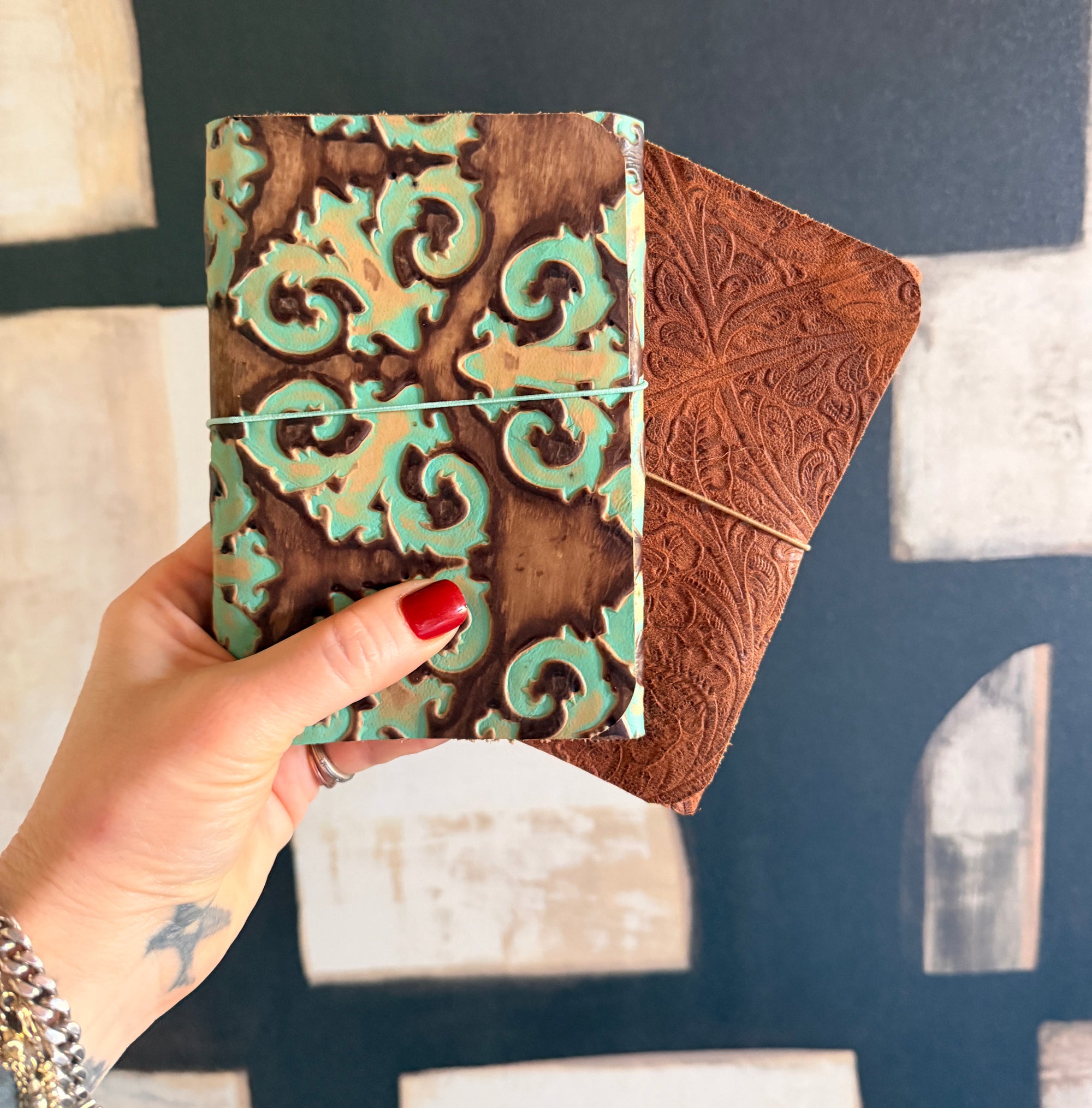 Two decorative notebooks with intricate patterns against a blurred background